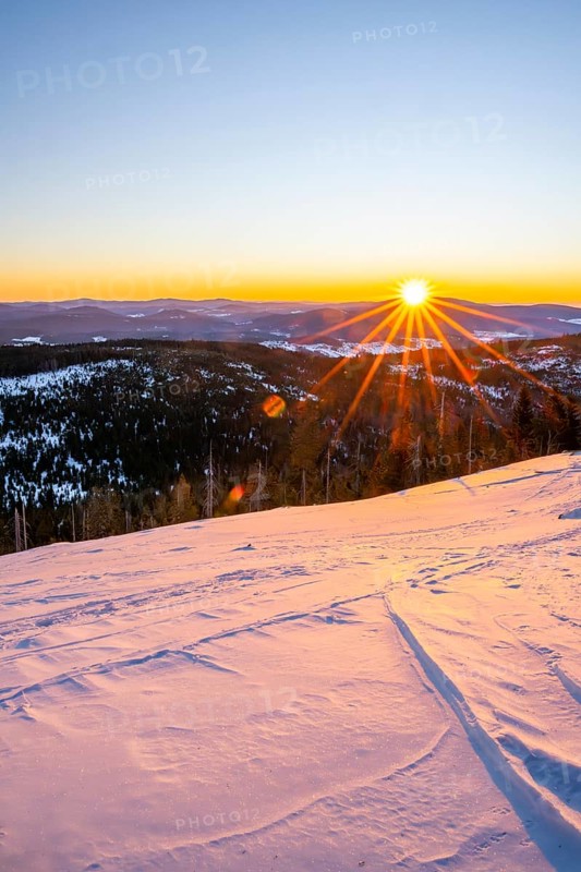 Sunrise over the hills of czech republic from Mount Lusen wth the view over the hills of the bavarian forest in winter, Bavaria, Germany