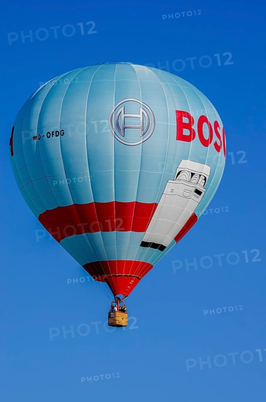 A hot air balloon, registration D-OFDG, rises into the air as part of an air show at the Fliegerbergfest of the Rossfeld Luftsportverein in Metzingen-Glems, Baden-Württemberg, Germany, for editorial use only