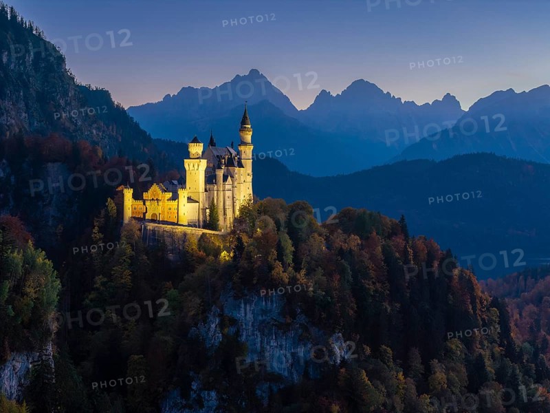 Sublime illuminated Neuschwanstein Castle on a ridge in the midst of an alpine landscape at sunset, Schwangau near Füssen, Ostallgäu, Allgäu, Bavaria, Germany