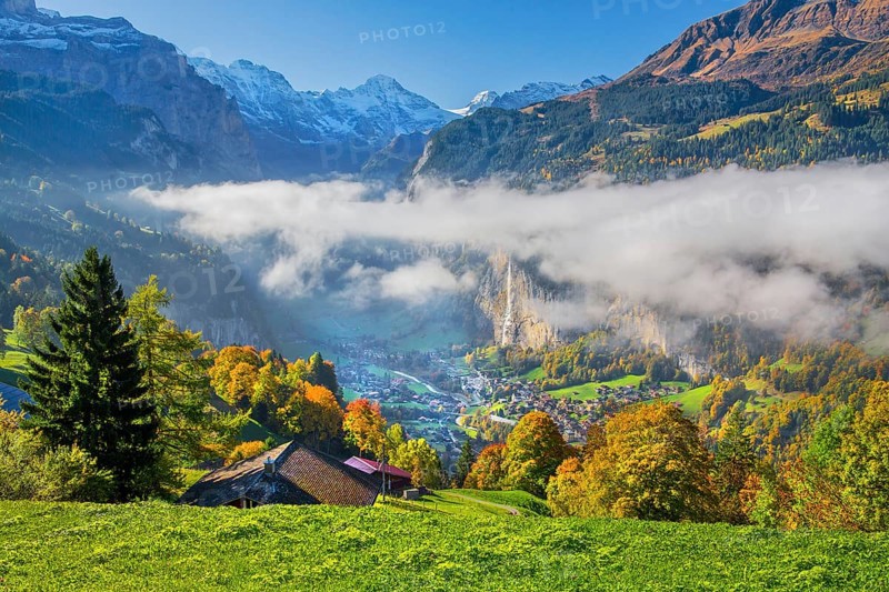 View from the village of the Lauterbrunnen Valley with Staubbach waterfall in autumn with morning fog, Wengen, Bernese Oberland, Canton of Bern, Switzerland