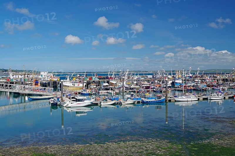 Full harbor with numerous boats, calm in the sea under sunny, blue sky, Mousehole, Cornwall, Great Britain