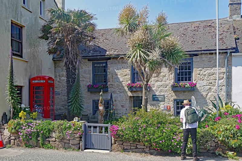 Stone house with blooming garden and red telephone box, Isles of Scilly, Hugh Town, Cornwall, Great Britain