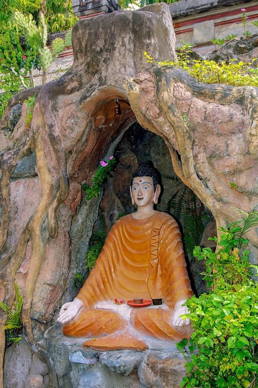 Statue figure of sitting Buddha in artificial grotto with hands shaped into thumb and index finger sculpting Jnana Mudra Gyan Mudra, Brahma Vihara Brahmavihara Arama Buddhist Monastery, Banjar, Bali, Indonesia