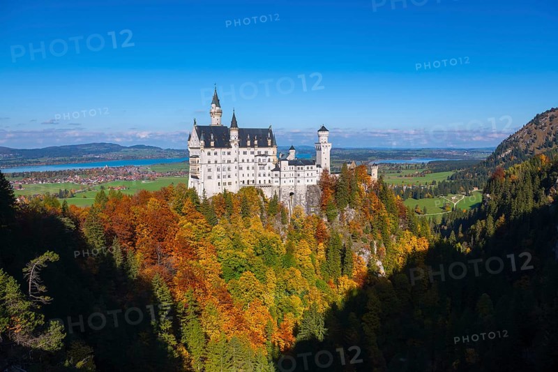 The magnificent Neuschwanstein Castle towers over an autumnal landscape with wide skies, Schwangau, Königswinkel, Ostallgäu, Allgäu, Swabia, Bavaria, Germany