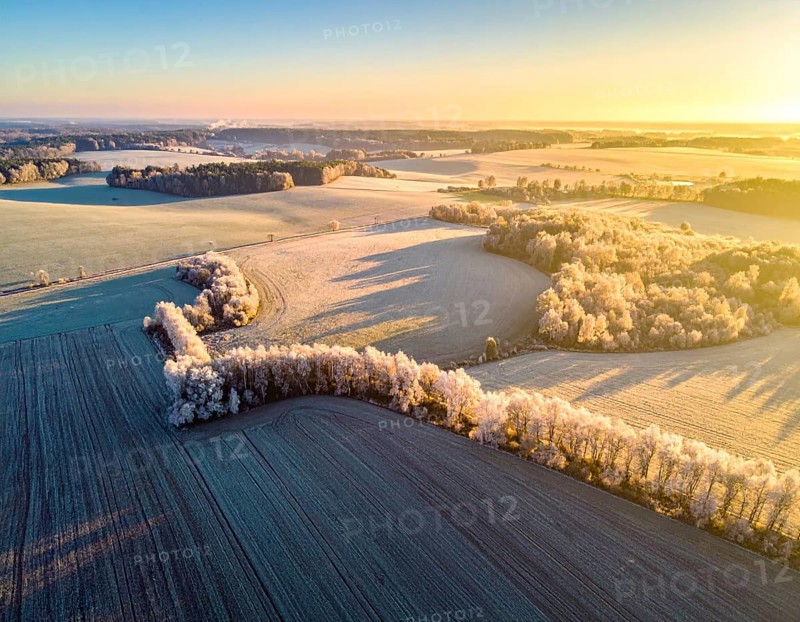 Bird Eye Perspective of Frost Covered Farmland. Seasonal Agricultural Scenery, winter and autumn scene, blue sky with golden light at sunrise, AI generated