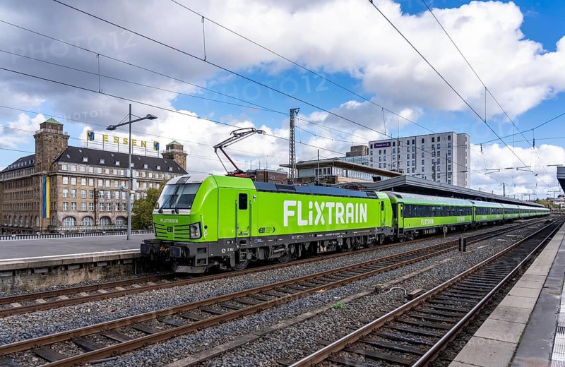 Flixtrain train on track 2 in Essen main station, view of the city center, Handelshof building with Essen lettering, North Rhine-Westphalia, Germany