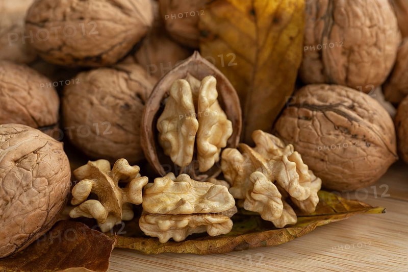 Fresh, delicious walnuts from Germany with leaves on a wooden board
