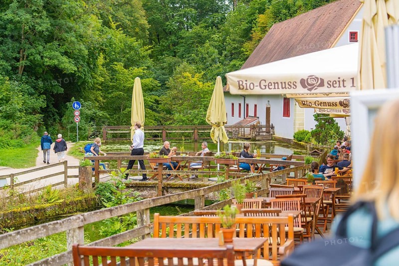 People relax in a café with a view of walkers in the countryside, Wimsener Höhle, Hayingen, Germany