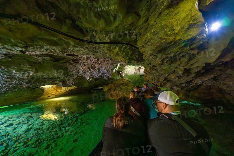 Group on a boat expedition exploring the fascinating waterways in a cave, Wimsener Höhle, Hayingen, Germany