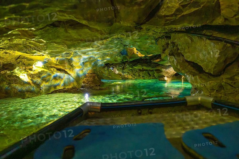View from a boat of the impressively illuminated interior of a cave with running water, Wimsener Höhle, Hayingen, Germany