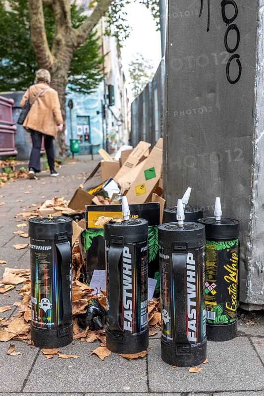 Empty cartridges filled with N2O, nitrous oxide gas, called laughing gas, officially it serves as a propellant to produce whipped cream in appropriate devices, but is often used as an intoxicant, party drug, misused, here mass, illegal disposal in addition to waste paper containers in Düsseldorf, North Rhine-Westphalia, Germany