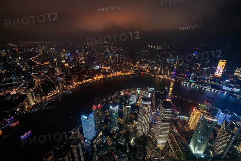 Aerial view over The Bund, Huangpu River and Lujiazui financial district with illuminated skyscrapers, in Pudong at the city Shanghai at night, China