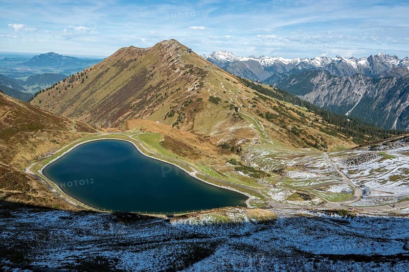Reservoir, Kanzelwand snow-making pond, behind Fellhorn and mountains of the Allgäu Alps, Vorarlberg, Austria