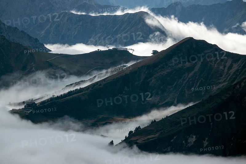 View from the Nebelhorn summit to mountains of the Allgäu Alps, in the middle of Fellhorn Horn with summit station and Kanzelwand cable car summit station, mountains rise from fog in the valley, Oberstdorf, Oberallgäu, Allgäu, Bavaria, Germany