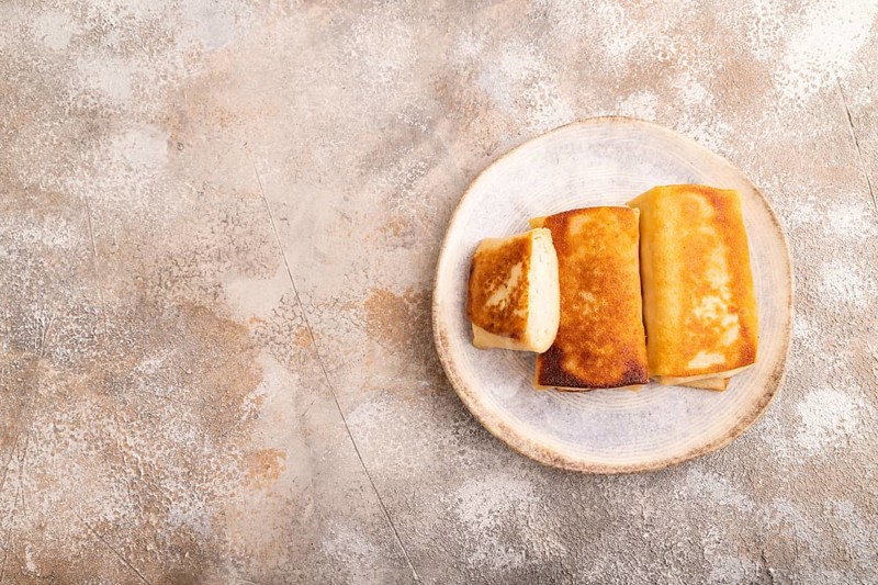 Fried crispy pancakes with meat and cheese on brown concrete background. top view, flat lay, copy space