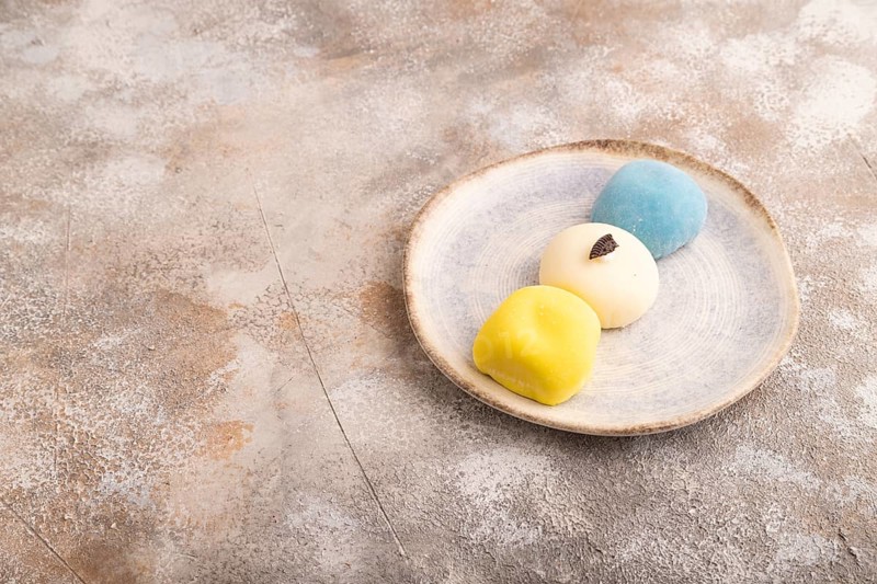 Japanese Mochi Cakes on brown concrete background, side view, copy space