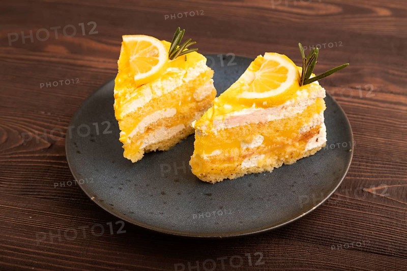 Lemon cake on brown wooden background, side view, copy space
