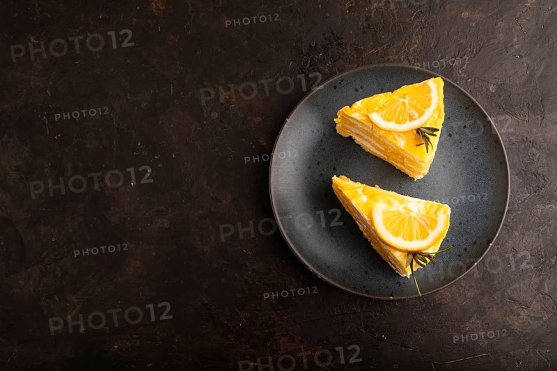 Lemon cake on black concrete background, top view, flat lay, copy space