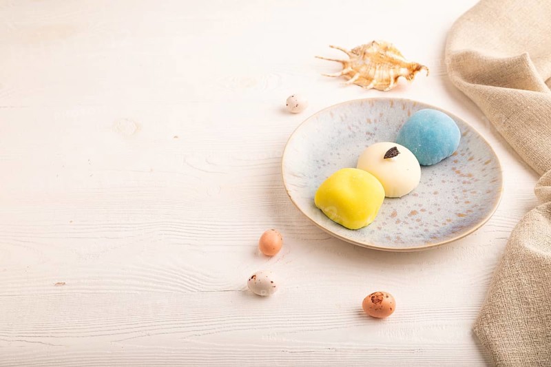 Japanese Mochi Cakes on white wooden background and linen textile, side view, copy space