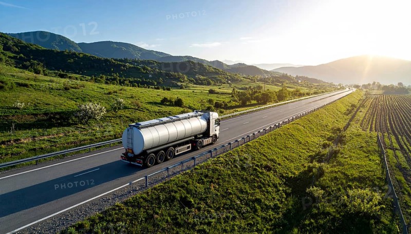 Petrol cargo truck lorry tanker driving on highway hauling oil products at sunrise, wide hilly landscape, AI generated