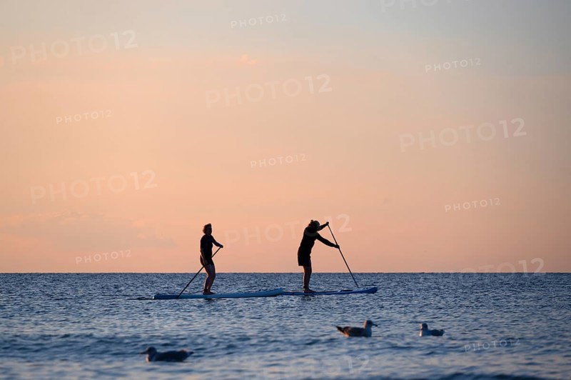 Two stand up paddlers on the Baltic Sea in the evening light, Ahrenshoop, Darß, Mecklenburg-Western Pomerania, Germany