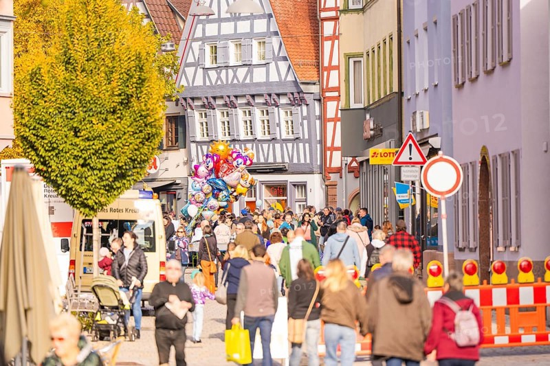 View of a busy street with half-timbered houses, construction site and crowd in the city, Urschelherbst street festival, Nagold, Germany