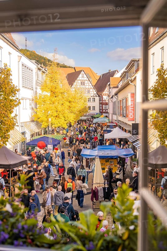 View from the window of a lively street with market stalls and an autumnal atmosphere in the old town, Urschelherbst street festival, Nagold, Germany