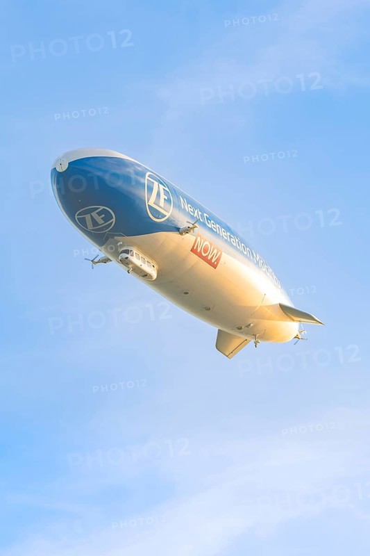 Zeppelin flies in evening light with clear sky, shows advertising message, Überlingen, Lake Constance, Germany