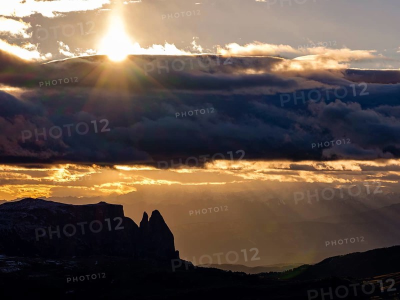 View of the Sciliar under dark clouds with sun, Dolomites, Trentino, South Tyrol, Italy