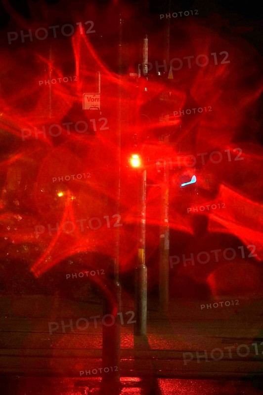 Traffic light, road traffic at night and poor visibility in a city, autumn, Germany