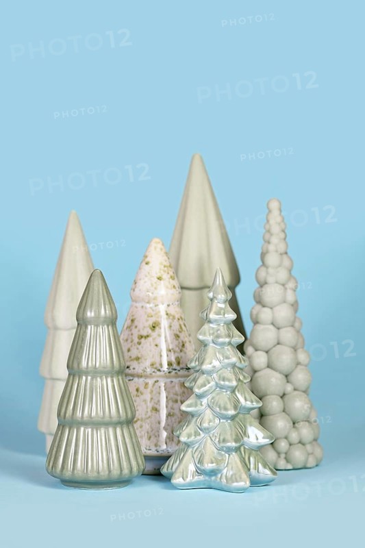 Beautiful different shaped light green ceramic Christmas trees on blue background