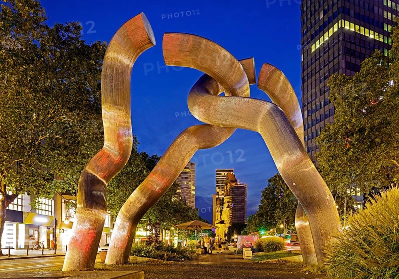 The sculpture entitled Berlin by Brigitte and Martin Matschinsky-Denninghoff with Kaiser Wilhelm Memorial Church in the evening, Charlottenburg, Berlin, Germany