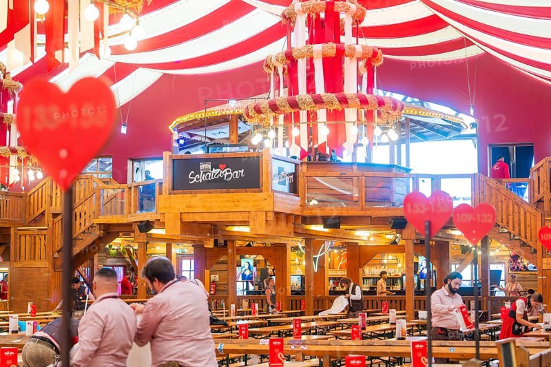 Interior view of a festively decorated beer tent with heart decorations and a bar in the centre, Volksfest Cannstatter Wasen, Sonja Merz Festzelt, Stuttgart, Germany
