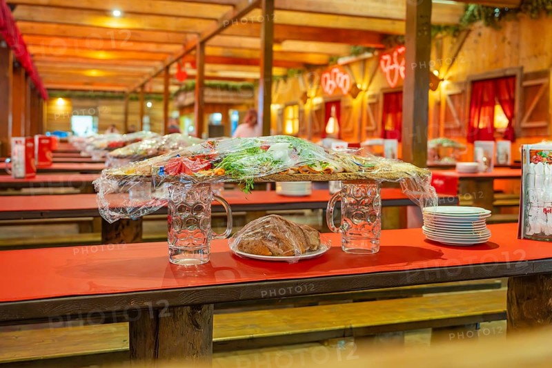 Covered food and beer mugs on red tables in a traditionally decorated tent, Volksfest Cannstatter Wasen, Sonja Merz Festzelt, Stuttgart, Germany