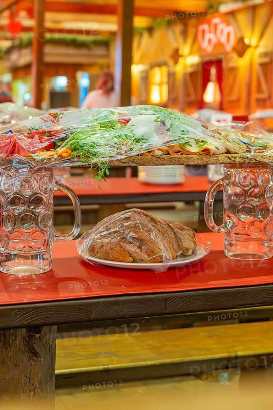 Close-up of beer mugs and packaged food on red tables in the marquee, Cannstatter Wasen folk festival, Sonja Merz marquee, Stuttgart, Germany