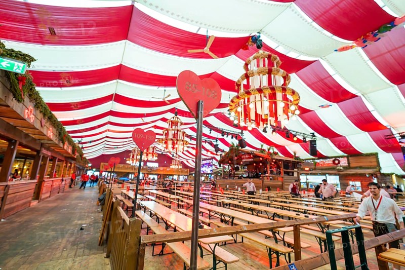 Cosy beer tent with red blankets, wooden benches and hearts as decoration, Volksfest Cannstatter Wasen, Sonja Merz Festzelt, Stuttgart, Germany