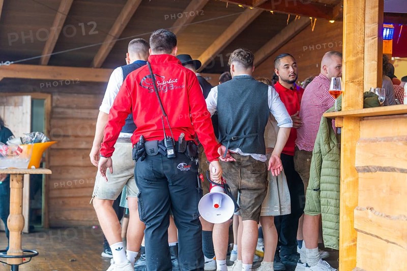 Group of people in traditional traditional costume crowding into an interior with wooden panelling, Cannstatter Wasen folk festival, Sonja Merz marquee, Stuttgart, Germany
