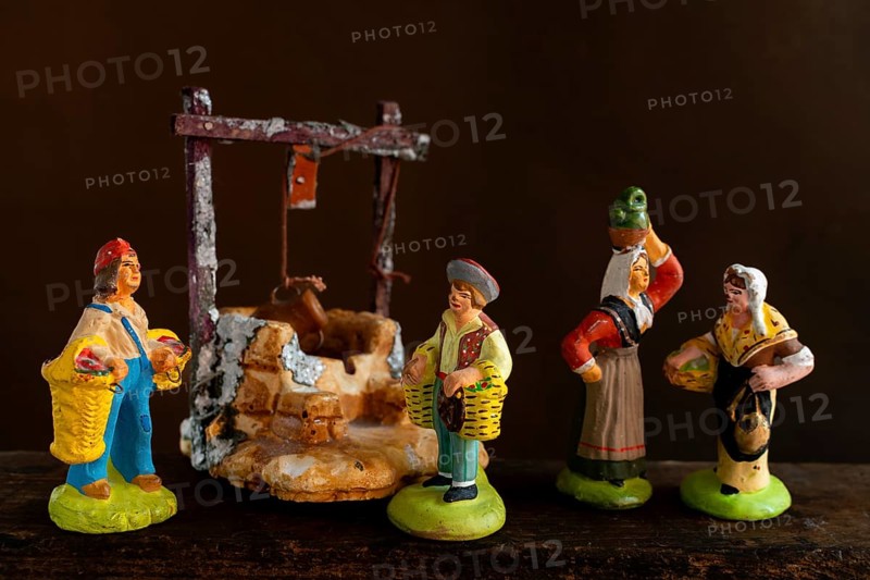 Colorful Provençal terracotta Santons figurines showcase characters engaged in various activities, featuring artisans, farmers, and market sellers