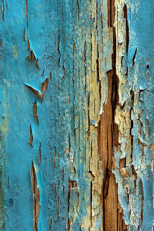 Faded blue wood shows signs of age with peeling paint, highlighting the textures and patterns associated with weathered materials. This scene captures a sense of history and rustic charm