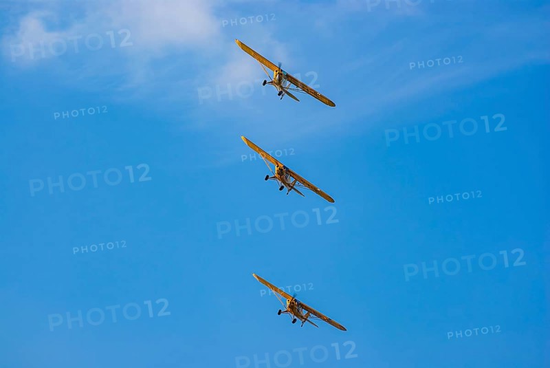 Three Piper PA-18 Super Cub aeroplanes of the Bravo Lima Formation flying in formation during an air show at the Rossfeld in Metzingen-Glems, Baden-Württemberg, Germany, for editorial use only