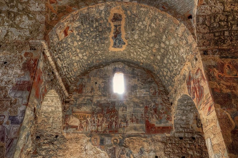 Post-Byzantine church of Agios Nikolaos from the 17th century AD, Ancient frescoes decorate the stone walls of an old church, light enters through a window, Mystras, Mistra, UNESCO World Heritage Site, Medieval Byzantine ruined city, northwest of Sparta, foothills of the Taygetos Mountains, Peloponnese, peninsula, Greece