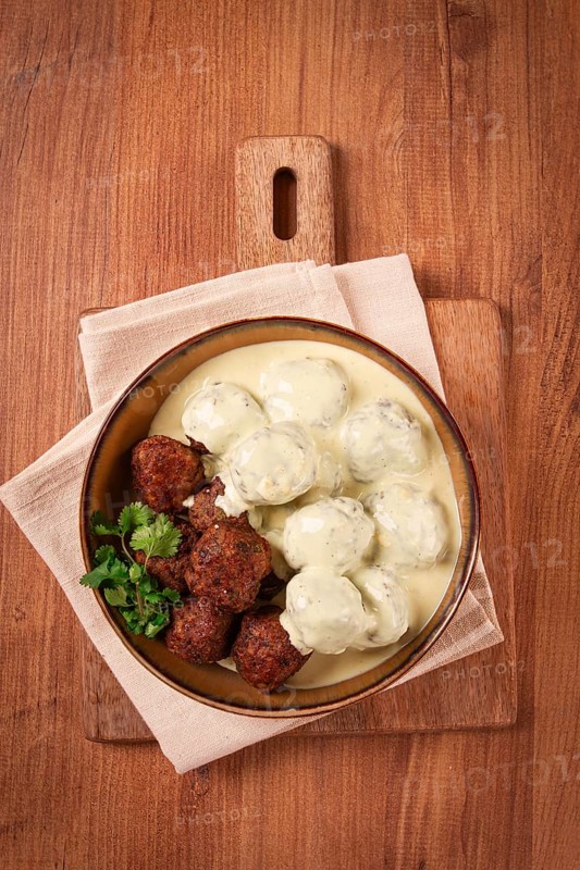 Swedish meatballs in cream sauce, plate on a wooden table, homemade, no people