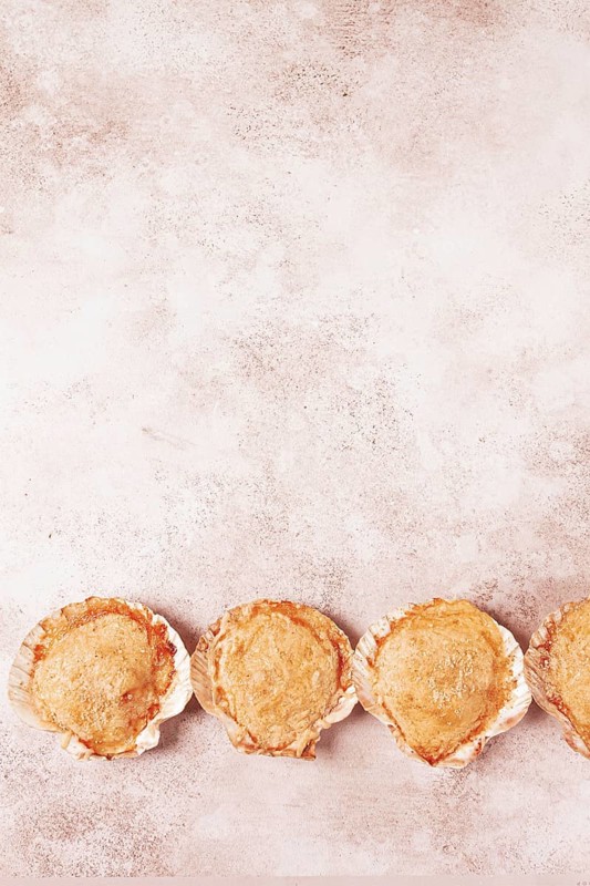 Scallop, baked in shells, with cheese and spices, on the table, homemade