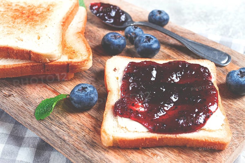 Toast with blueberry jam, on a wooden chopping board, breakfast, homemade, no people