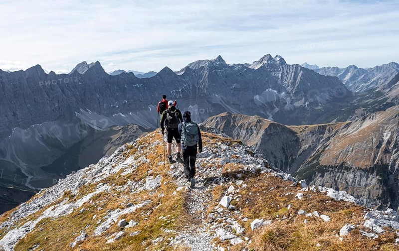 Mountain panorama with picturesque mountain landscape, group of mountaineers descending from the Gamsjoch, in autumn, behind mountain ridge of the Hinterautal-Vomper chain, Rißtal in the Eng, Karwendel, Tyrol, Austria