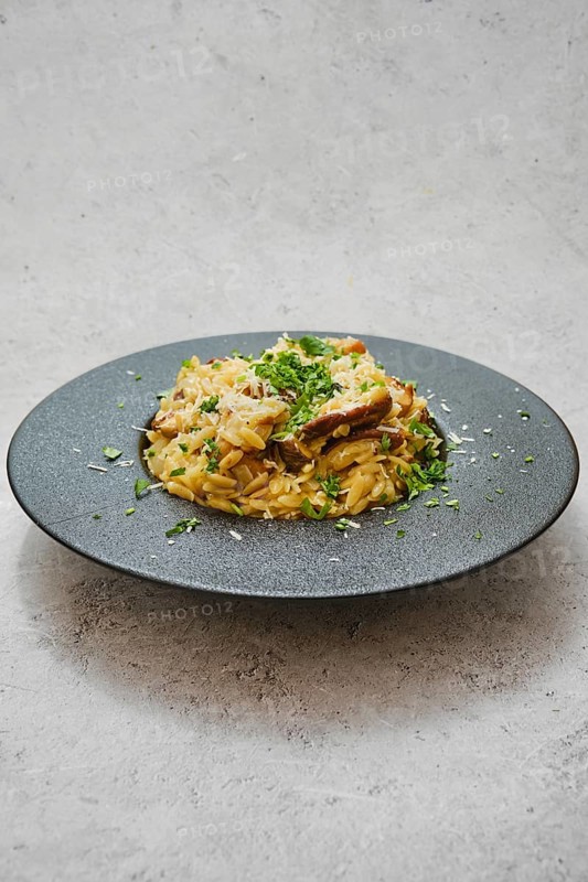 A beautifully plated dish featuring risoni pasta mixed with rich porcini mushrooms