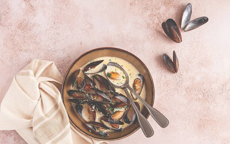 Mussels in creamy garlic sauce, served with fresh herbs and spices, homemade, no people