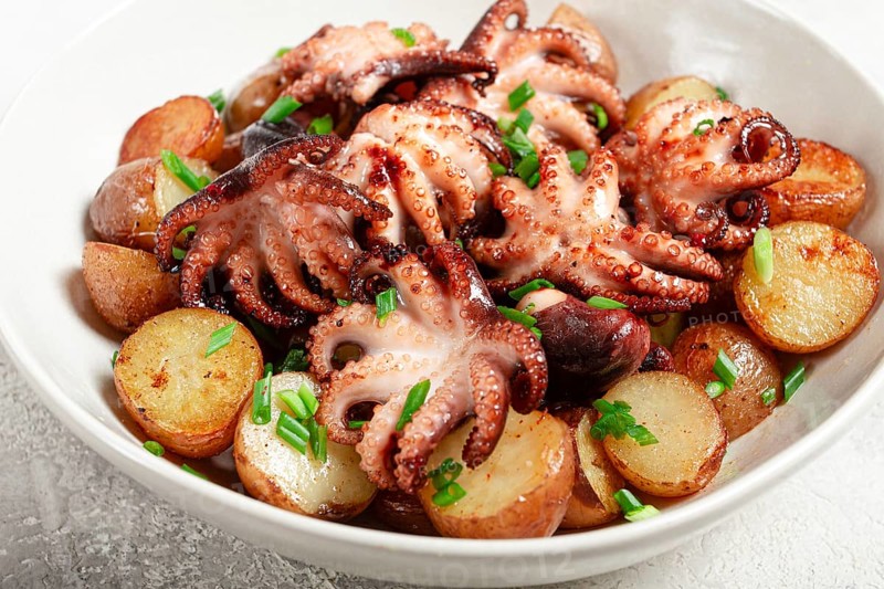 Baby grilled octopus with golden baked potatoes and fresh herbs, Maltese cuisine, homemade, no people