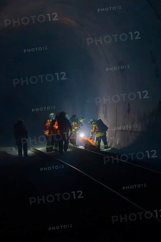 Group of firefighters in the tunnel, illuminated by a light source, fire drill in the new tunnel of the Hermann Hesse railway, Ostelsheim, district of Calw, Germany