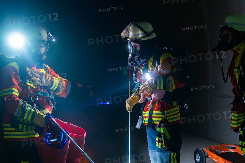 Firefighters in action on rails, equipped with helmets and torches, fire drill in the new construction tunnel of the Hermann Hesse railway, Ostelsheim, district of Calw, Germany